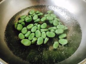 蚕豆可提前焯水，也可直接炒，焯水时一定要用开水焯水，水里放一点盐和两滴油，因为蚕豆很嫩，焯水时间不能过长，避免蚕豆太软，影响口感，水开后汆烫1分钟左右即可，捞出沥干水分备用。