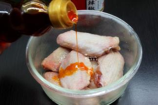 鸡翅放入玻璃碗中，放盐、姜粉、生抽、辣椒油均匀的按摩，腌制3小时以上。如果天气热，就用玻璃保鲜盒放入冰箱。
