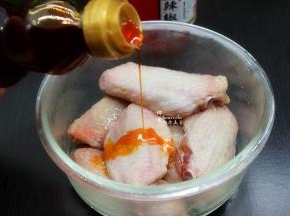 鸡翅放入玻璃碗中，放盐、姜粉、生抽、辣椒油均匀的按摩，腌制3小时以上。如果天气热，就用玻璃保鲜盒放入冰箱。