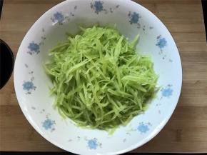 把刨好的莴笋擦成丝。