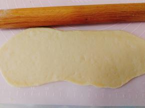然后用擀面杖擀成长条薄饼状。