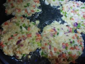 用勺子把米饭放电饼铛按平铺匀。