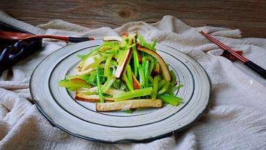 一道爽口、充满米醋香气的熏干炒香芹就做好了
