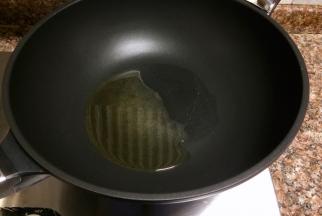 热锅倒油烧至八成热。