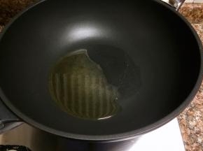 热锅倒油烧至八成热。