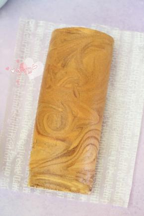 用擀面杖卷住油纸，顺势往上推，卷起来，两边跟拧糖一样拧起来。放入冰箱冷藏半小时后再切块食用。