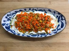 把蒸好的豆腐拿出来倒去水分，再铺上炒好的酸黄瓜肉末，撒上香葱即可。