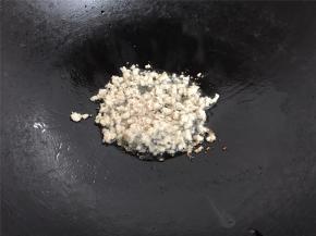 在蒸豆腐的时候来炒配料，锅中倒入少许油后把肉末放入。