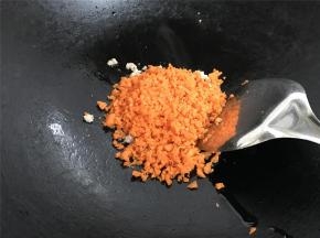 用锅铲把肉划散，等肉变色后放入胡萝卜末。