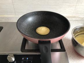 锅热后舀入一勺面糊，小火焙制，再盖上盖子焖2分钟，看到面糊表面起泡，则可以翻面