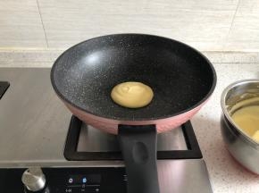 锅热后舀入一勺面糊，小火焙制，再盖上盖子焖2分钟，看到面糊表面起泡，则可以翻面