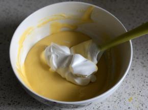 再刮取1/3的蛋白霜到蛋黄糊中，继续翻拌均匀