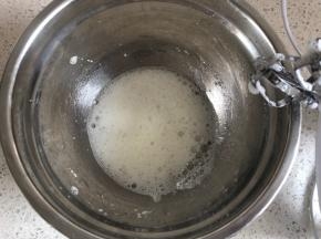 低速打发至粗泡状态，加入1/3的细砂糖，继续中高速打发
