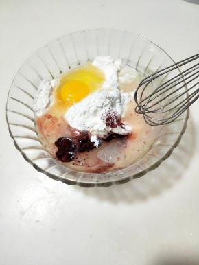 将一份鸡蛋仔预拌粉放在碗里，放入鸡蛋和植物油，加入红曲粉、
面糊调好之后静止备用。