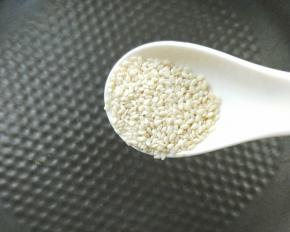 平底锅炒熟一勺白芝麻。