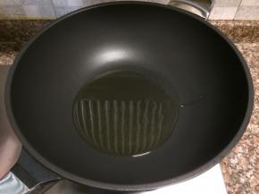 热锅倒油烧至八成热。