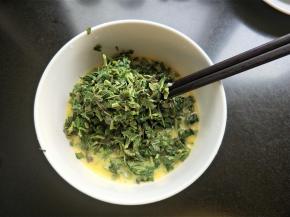 将香椿放入蛋液中。