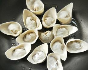 平底锅不粘锅放少许油，把馄饨放入，可以一次性放密集一些。