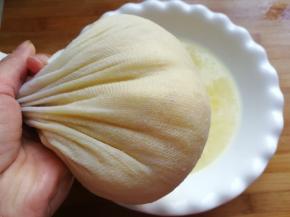 再把料理机中打的菠萝芯和切好的菠萝肉，一同放入纱布中挤干水分，不要挤太干，保留一些果汁炒出来的香味更浓郁