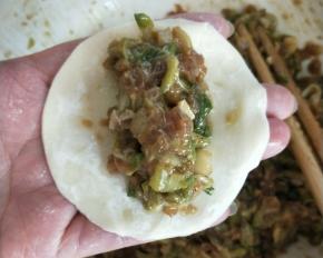 饺子皮一张，取槐花牛肉馅集中放饺子皮中间，用筷子夹一下肉馅边缘成长方形的感觉，饺子边最上方抹上一点水，对折捏紧中间，两边开口。