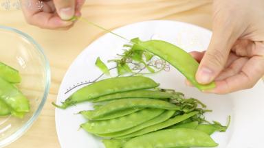 泡好的荷兰豆去除两端的丝络，再用清水冲干净。