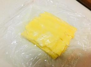 将黄油稍微软化，放在案板上，反复折叠反复敲打。中途可以稍微撒一些高粉，以免粘案板。