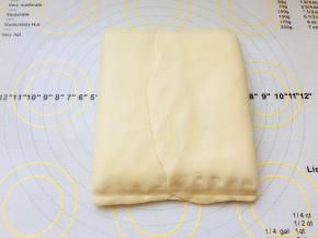 将黄油片包裹在面片中，按紧上下两端收口，轻按，将中间接缝位置按平些。