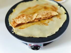 最后把翻过来的煎饼涂抹上自己喜欢的酱料，再把提前做好的脆饼放上面，（如果没有脆饼也可以放油条）还可以加入香菜，榨菜，火腿，咱们自己做的好处就是，可以按照自己的口味添加食材。