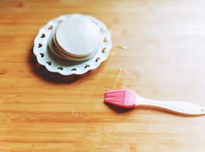 首先用硅胶刷在砧板上刷少许食用油。