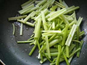 将芹菜段放入锅中。