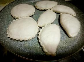 热锅凉油，放入韭菜盒子生胚，中小火煎。