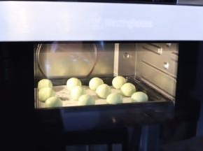 启动烤箱，放入装有青团的烤盘，开始蒸煮