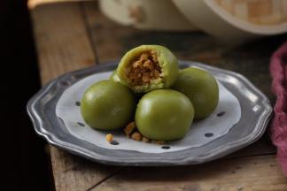 出炉的青团趁热刷上一层薄薄的色拉油防开裂，温热时包上保鲜膜保持软糯