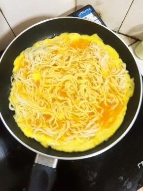 轻轻的晃动不粘平底锅，让面条都均匀的裹满蛋液。