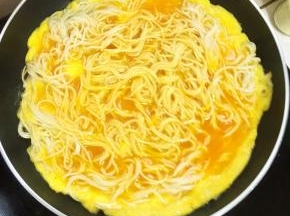 轻轻的晃动不粘平底锅，让面条都均匀的裹满蛋液。