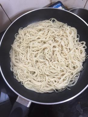 不粘平底锅烧热倒入适量的油，把煮好沥干水分的面条放入锅中小火煎制1分钟。