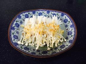 将步骤3炒好的蒜蓉放在金针菇的表面。