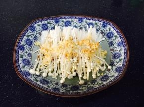 将步骤3炒好的蒜蓉放在金针菇的表面。