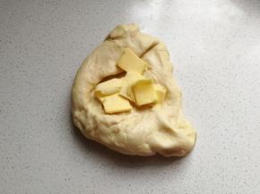 揉面至粗膜状态时加入室温软化的黄油继续揉面