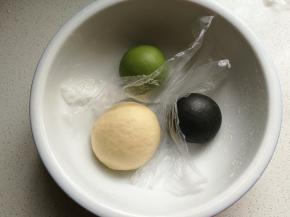 把三种颜色的面团放入大碗中，用保鲜膜隔开再盖上保鲜膜发酵