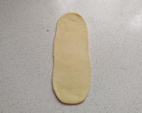 再把白色面团擀成长舌状