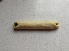 把白面皮两边包住黑色面团包紧捏实