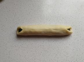 把白面皮两边包住黑色面团包紧捏实