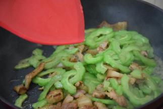 加入苦瓜，倒入少许清水翻炒至苦瓜变软