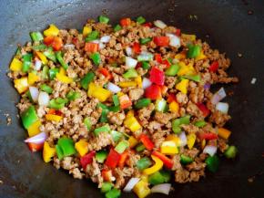 加入生抽、蚝油、老抽翻炒上色，关火后倒入彩椒洋葱丁翻炒均匀。