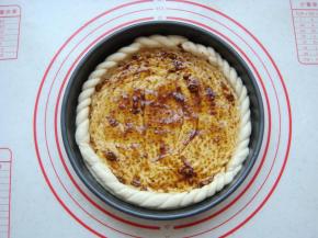 小面团搓成两个细条像拧麻花似的绕在一起。麻花边摆放在饼胚周围，刷上黑胡椒酱。