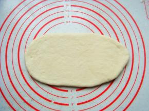 面团擀成与模具宽度一致的薄片。