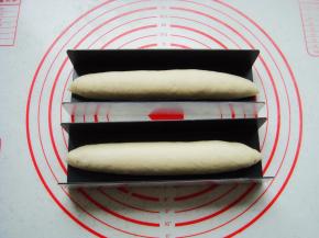 收口捏紧向下放入三能U形模具中，放置温暖处再次发酵稍微变大。