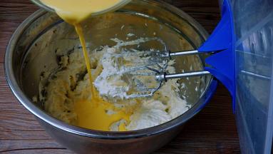 将蛋黄液分三次加入黄油中，搅打均匀，以免水油分离