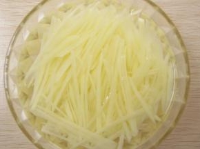 焯熟的土豆丝放入凉开水中冲洗。